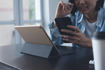 Canvas Print - Asian business woman using mobile phone working on digital tablet and laptop computer at home