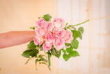 Fototapeta Góry - Women hand holding a bouquet of Luciano roses variety, studio shot.