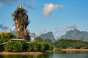 Kyaut Ka Latt Pagoda, located on an island in the middle of the water, is a famous temple in the city of Hpa-An, Myanmar. In the evening, the blue sky with beautiful clouds.