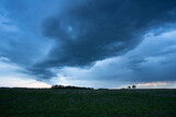 Fototapeta  - Nimbostratus Of Gray-Blue Color Over Agricultural Field In Evening Dusk In Spring.