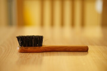 Poster - Closeup shot of a wooden shoes brush on a wooden surface