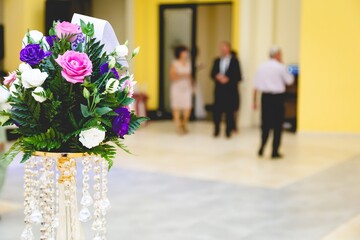 Canvas Print - Vertical shot of a bouquet with people dancing on a blurred background