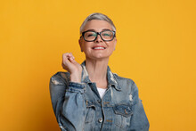 Eyewear Fashion. Happy Middle-Aged Woman Posing In Stylish Eyeglasses Over Yellow Background