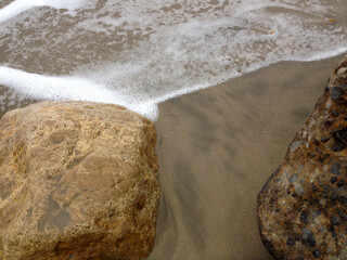 Natural background Beach surf coastline sand foam rocks stone