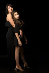 Mom and daughter in the studio on a black background.