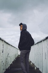 Sticker - Beautiful shot of a male wearing a jacket posing in between a fence