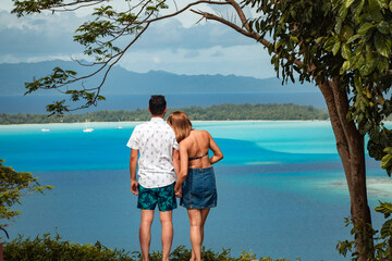 beautiful couple posing with tropical island in background