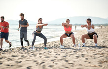 Group Of Friends  Is Exercise On The Beach By The Sea.fitness, Sport And Healthy Lifestyle Concept