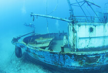 Scuba Divers Exploring Underwater Ship Wreck 