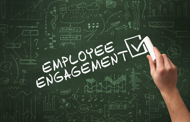 Hand drawing EMPLOYEE ENGAGEMENT inscription with white chalk on blackboard, new business concept