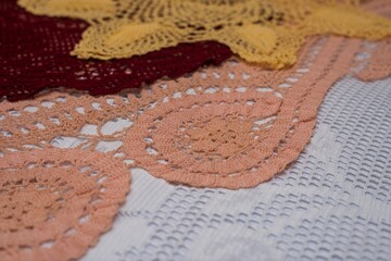 Canvas Print - Closeup shot of three crochet doilies, one red, one pink and one yellow, on a white surface