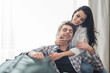 © LIGHTFIELD STUDIOS - Selective focus of smiling woman embracing handsome boyfriend on sofa at home