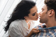 © LIGHTFIELD STUDIOS - Beautiful woman kissing handsome boyfriend near window at home