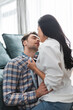© LIGHTFIELD STUDIOS - Selective focus of handsome man kissing seductive girlfriend near couch