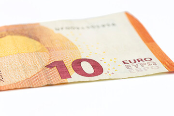 Macro shot of a European Union banknote of 10 EUR, close-up of the number ten, isolated on a white background, selective focus.