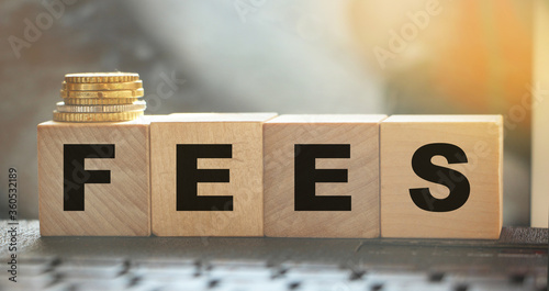 Fotografía Coin stack and wooden blocks with the fee text