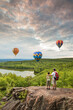 © romylee - father and son hikers watching hot air balloons in the distance