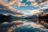 Fototapeta Na sufit - Lake Bled island with church in beautiful morning sunrise golden hour. Amazing colors in the sky and water surface. Low angle view, wide shot