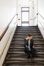 Mature Woman Sitting On Stairs Using Phone