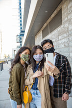 Brother And Sisters In Face Masks Using Smart Phone