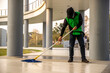 A  janitor man  cleaning  mopping floor in office building or walkway modern building.