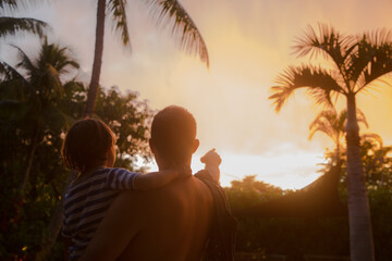 Father and Son Enjoying the Beautiful Tropical Sunset Sky