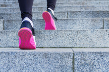 Closeup Of Athletic Female Legs In Colorful Sneakers. Young Woman Girl Is Doing Exercises, Training, Jogging, Jumping On Steps Of Stadium. Gymnastics Outdoor. Sport And Healthy Lifestyle Concept.