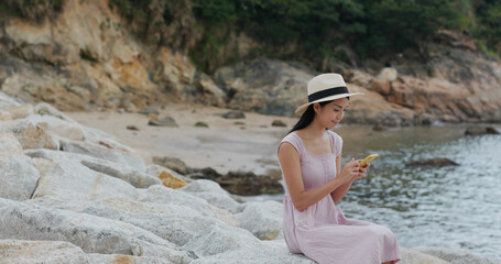 Canvas Print - Travel woman sit on the rock at seaside