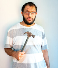 Arabic man holding a hammer infont of his chest