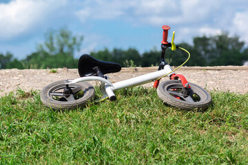 children's bike lies on the grass.