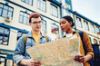 © BullRun - Multicultural tourists dressed in casual wear holding travel map in hands and looking for showplaces in new town.Diverse young man and woman travelers searching route during trip on weekend