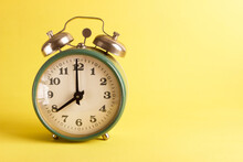 Green Alarm Clock On The Yellow Background