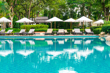 Umbrella and chair around swimming pool in hotel resort