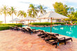 © topntp - Umbrella and chair around swimming pool in resort hotel for leisure travel and vacation neary sea ocean beach