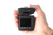 © Дмитрий Шкода - Male hand holds a black car DVR with a folding screen in the off state close up isolated on a white background