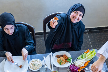 Wall Mural - Happy arabic muslim family enjoying the food togther in ramadan