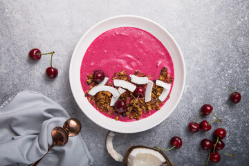 Pink Smoothie from Banana and cherry  Granola and Coconut Shreds on top. Healthy summer breakfast, top view