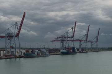 Wall Mural - View at Dunkirk from the Canal between England and France on industry, cranks, container ships and port of Dunkirk in France