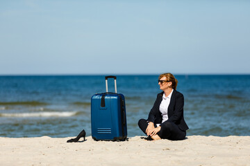 Wall Mural - Businesswoman sitting on beach
