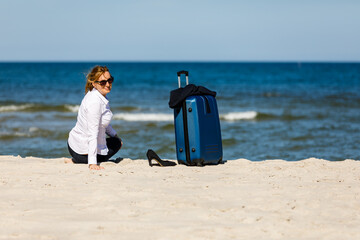 Wall Mural - Businesswoman sitting on beach
