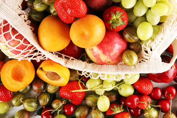 Wall Mural - Fresh summer fruits in eco bag with apple, grapes, berries, plums and healthy apricot.