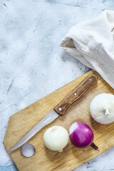 Sticker - Vertical shot of three onions on the cutting board next to the knife