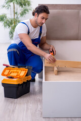 Wall Mural - Young male contractor installing furniture at home