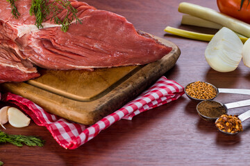 beef steak on cutting board accompanied by onion, garlic and various spices