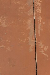 Poster - Vertical shot of a crack inside the brown wall