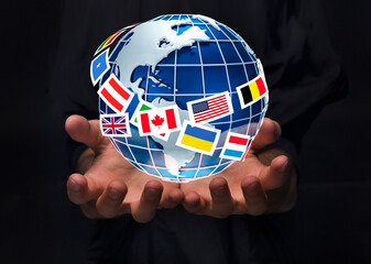 Fototapete - Closeup of man holding planet Earth surrounded by international flags on black background, collage