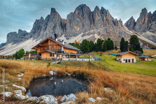 Cuadros en Lienzo Cute alpine wooden chalets with small pond in Dolomites, Italy