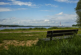 Fototapeta Do pokoju - wooden bench on the river promenade