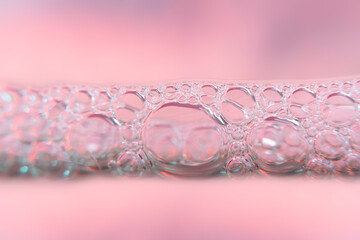  Blurred background with water line and bubbles in pink tones in high magnification.