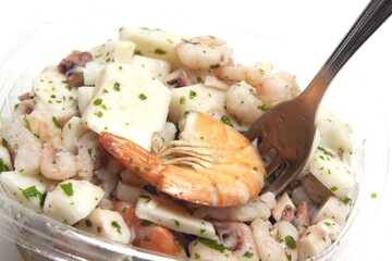 Sticker - Closeup of seafood salad in a transparent transport tray isolated in white background